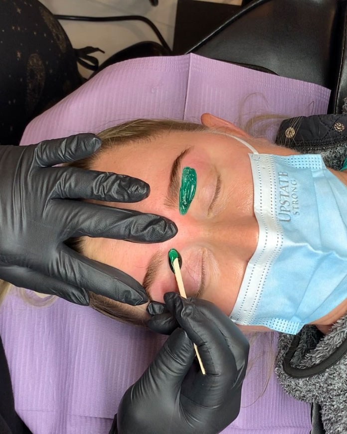 Eyebrow shaping service using waxing technique at Painted Lady Studios.